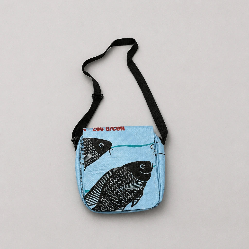 Upcycled crossbody bag with blue fish design on a light gray background
