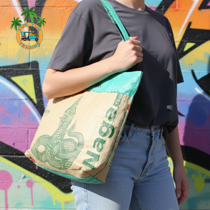 Person holding a tote bag with 'Naga' branding against a colorful graffiti background. Tote available at ShopTukTuk.com