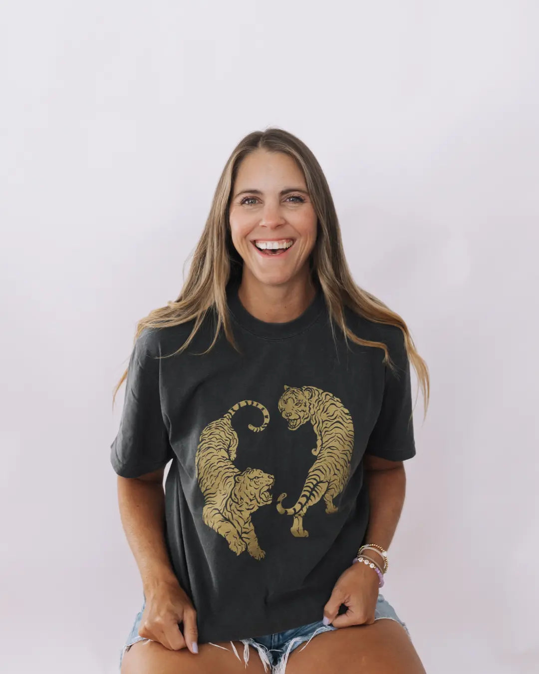 Woman wearing a charcoal tshirt with two golden tigers from Tuk Tuk Trading