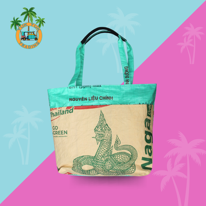 Tote bag made from recycled material on a colorful background with palm tree graphics. Tote from TukTuk Trading