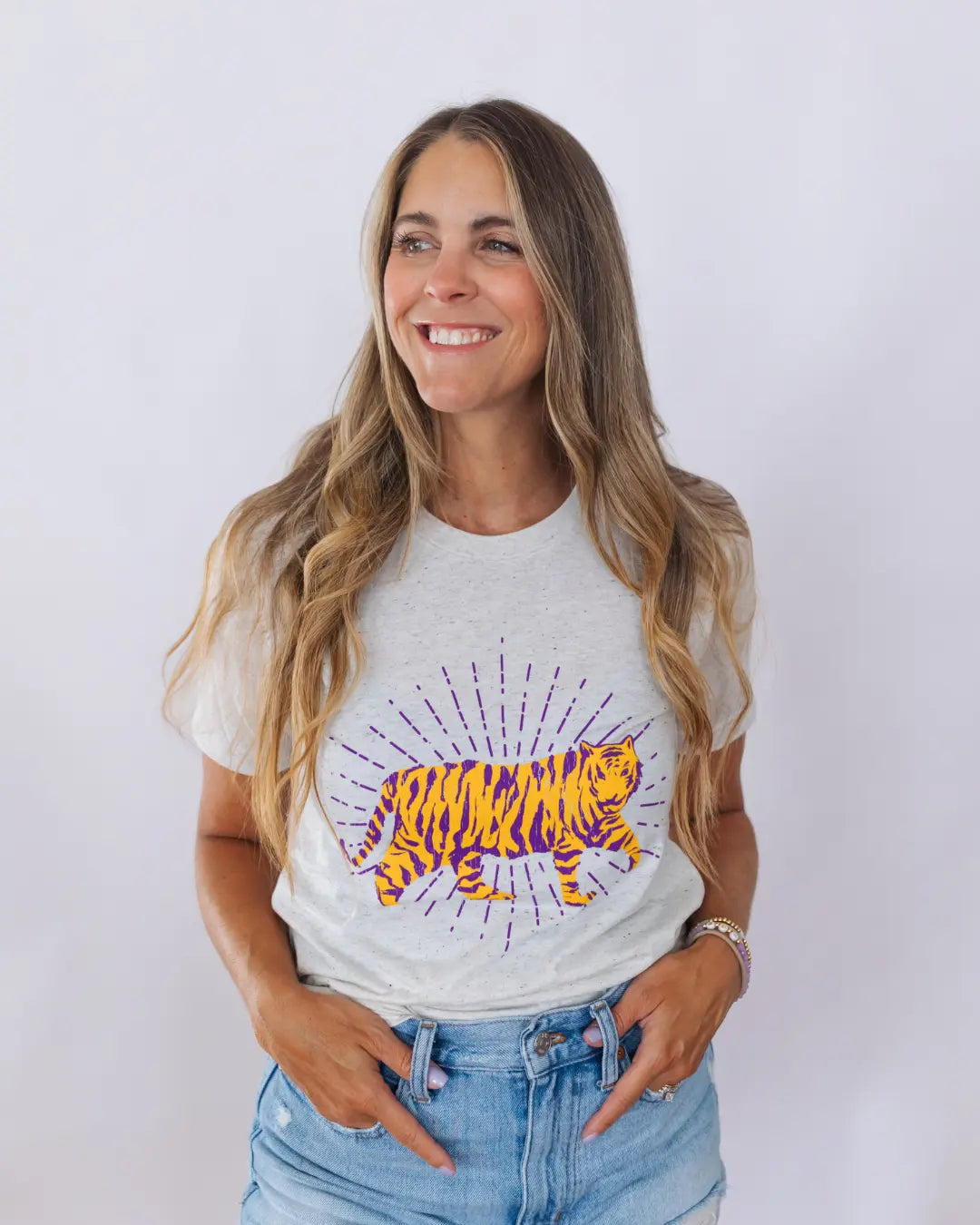 Woman wearing a white t-shirt with a colorful graphic design of a tiger on a plain background. available at ShopTukTuk.com