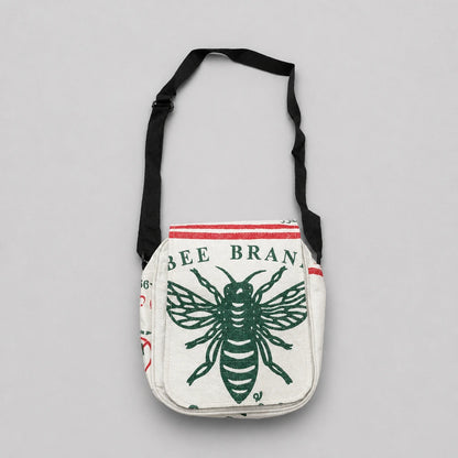 Upcycled crossbody bag with bee design and 'Bee Brand' text on a gray background