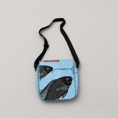 Upcycled crossbody bag with blue fish design on a light gray background